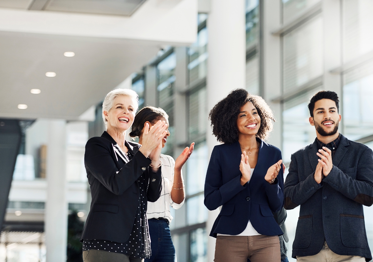 A group of diverse professionals applauding their company's internal strategy for effective talent sourcing