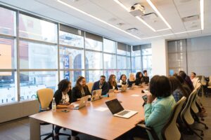 A group of employees sit at a large conference table.