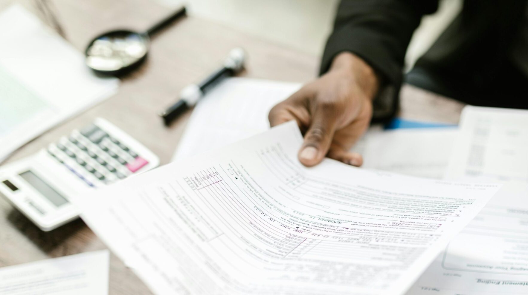 Person sitting at a desk holding tax documents. what is imputed income.