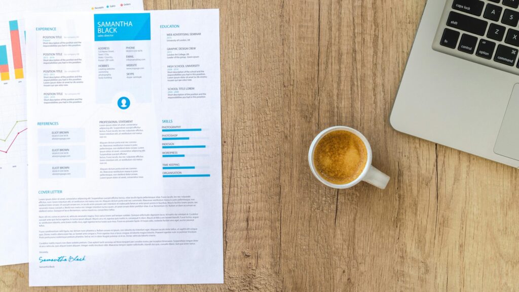 Resume on a table with coffee and laptop. How to find a recruiter.